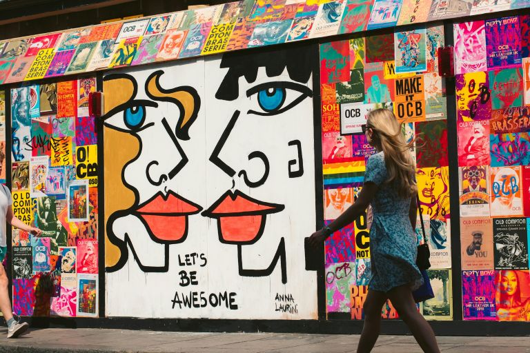 Un mur amb pintades i cartells suggestius d’una moralitat «moderna».