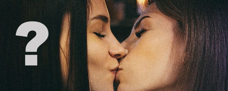 Un interrogant en una foto lleugerament difuminada de dues noies lesbianes que es besen.